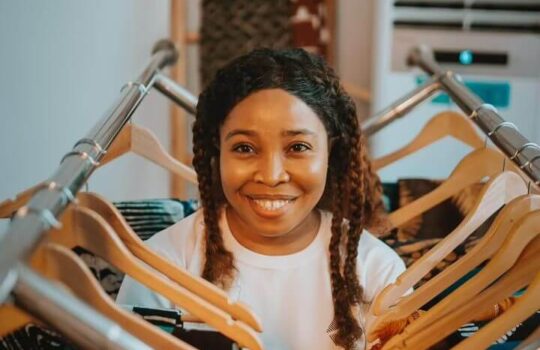 Afrikstabel CEO Founder standing between fabrics in collaboration with DexStitches Fashion website