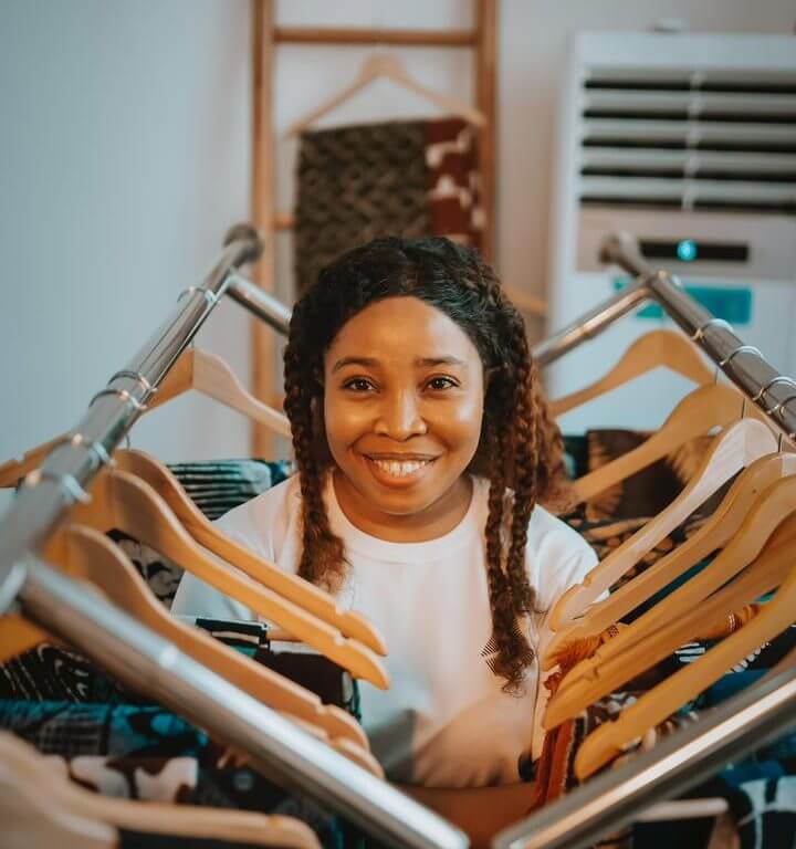 Afrikstabel CEO Founder standing between fabrics in collaboration with DexStitches Fashion website